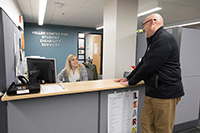 Student and staff member at front desk of Miller Student Center