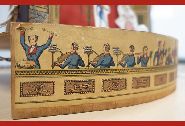 close up view of a historic toy theatre showing images of musicians