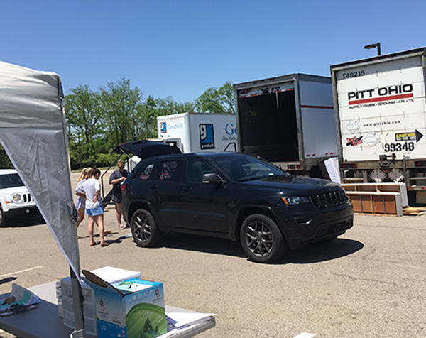 a donation drop off at Sharefest 2022 in a truck at Chestnut fields with several people gathered around a black SUV