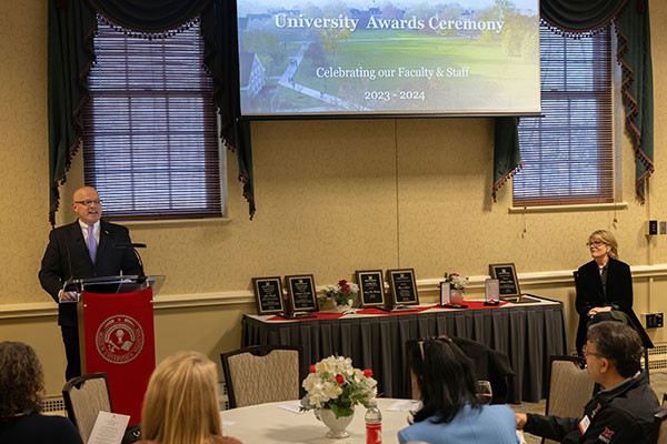 President Gregory Crawford speaks at the awards ceremony at provost Elizabeth Mullenix, who is sitting nearby, looks on.