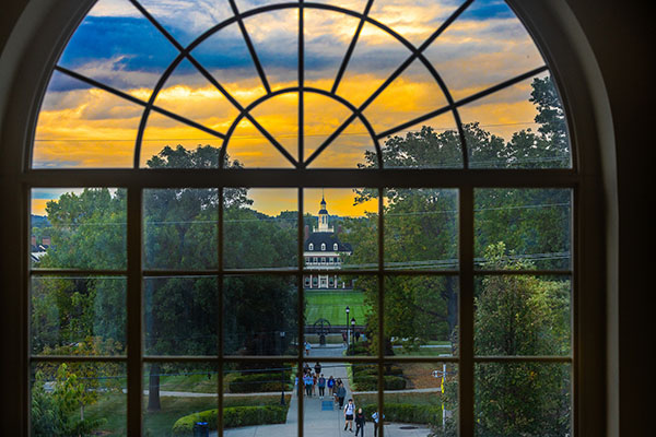 MacMillan Hall seen through an arched window at sunrise photo by Scott Kissell