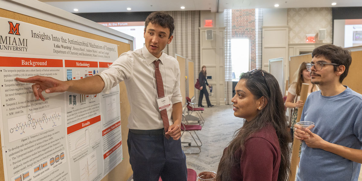 Luke Wardrip presents his research to visitors at the forum