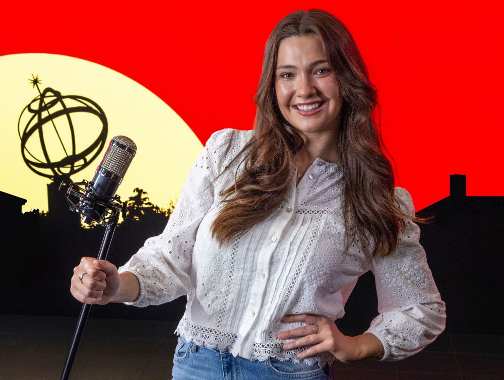 Michaela Buck, podcast host, sitting outside with a mic