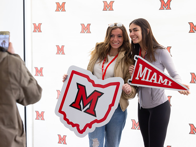 Two students posing with Miami University swag
